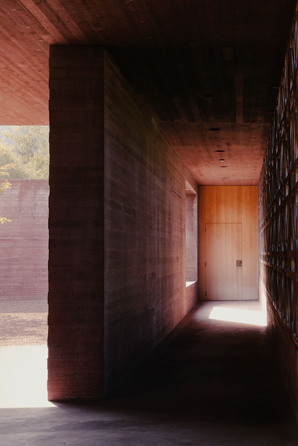 Earthen-walled corridor leading to a sunlit doorway