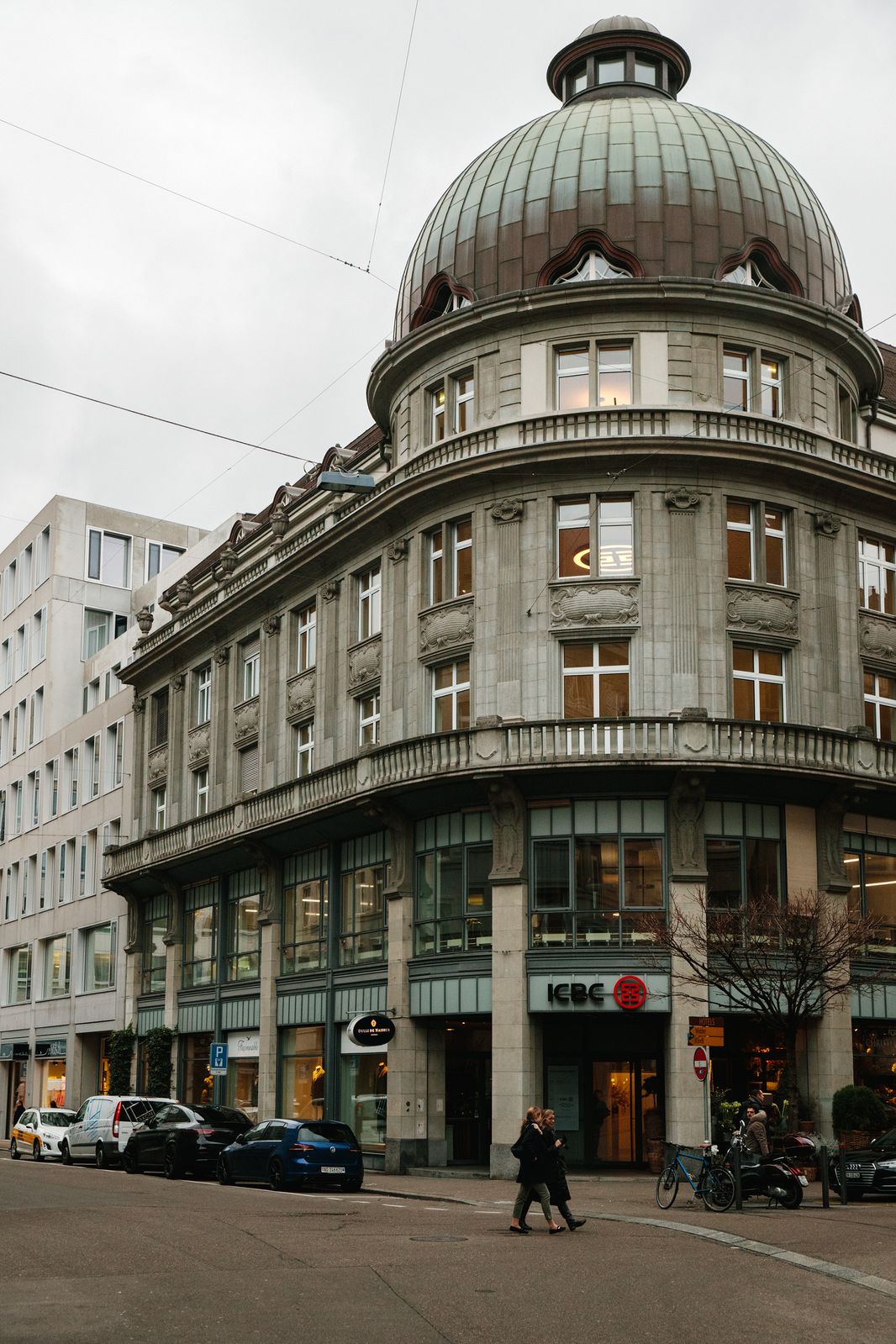 Historic corner building with a green copper dome in Zurich